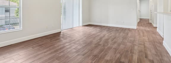 A room with wooden flooring and a ceiling fan.